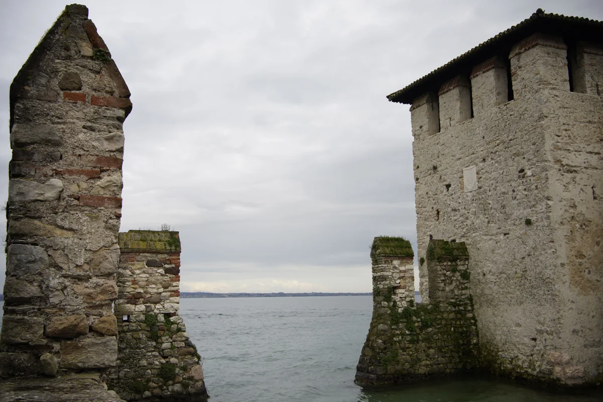 Kamenné věže Scaligerského hradu pohledem z hladiny jezera v Sirmione